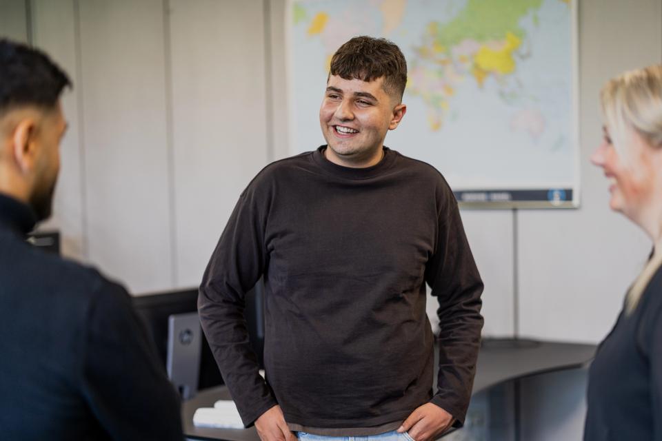 Ung mand, der står sammen med sine kollegaer