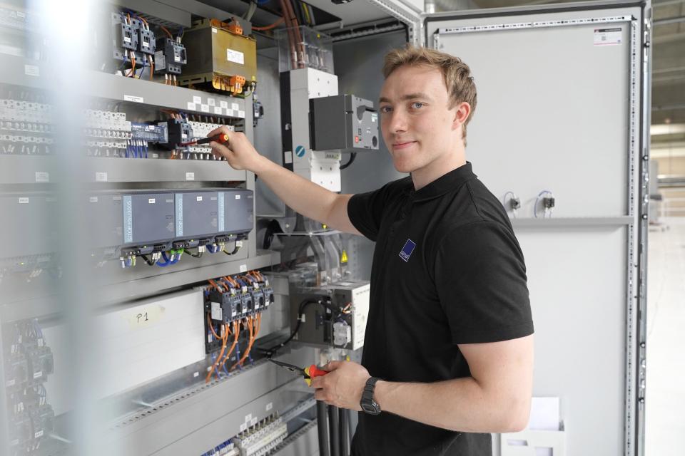 Ung mand, der arbejder ved en eltavle