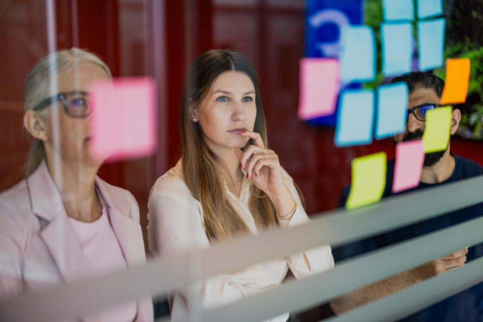 Medarbejdere, der kigger på post-its på væg