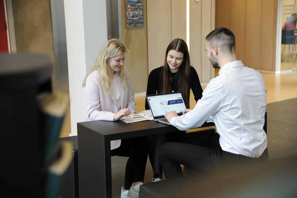 Unge mennesker, der sidder sammen ved et bord