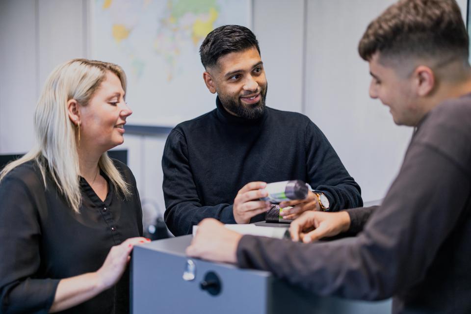 Medarbejdere, der står sammen og snakker over en rulle affaldsposer