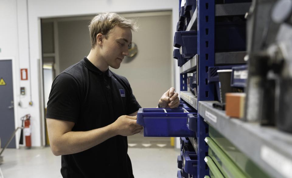 Ung mand, der kigger i en skuffe med reservedele