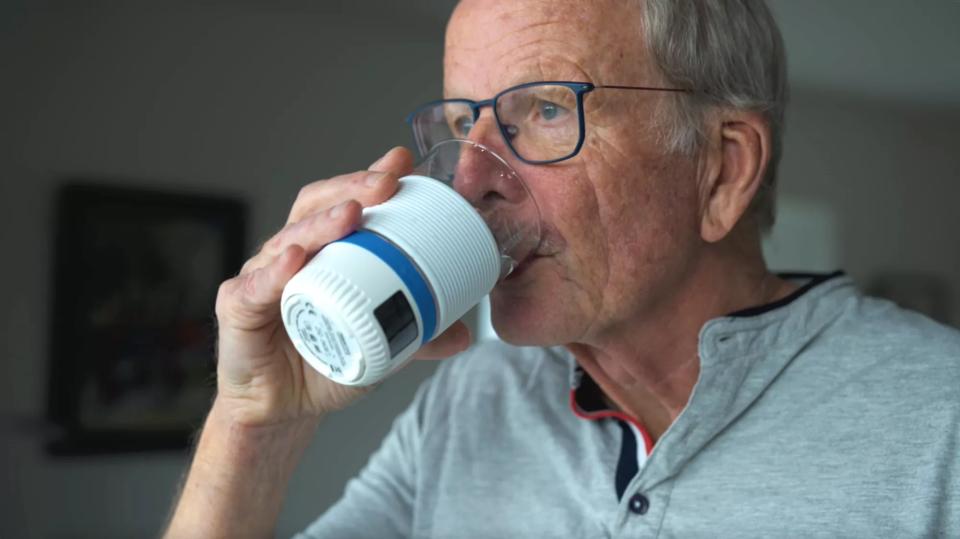 Mand, der drikker af AQUATIME glas
