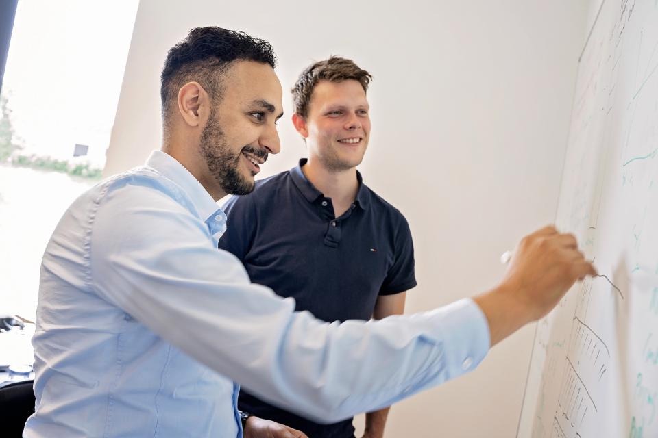 To medarbejdere, der ligger på en computerskærm