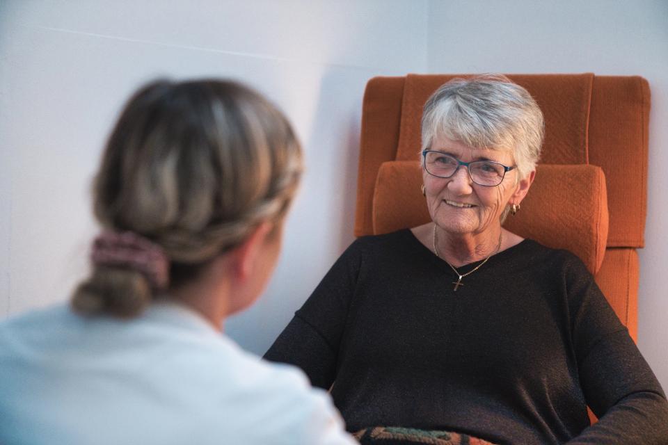 Borger og plejepersonale, der sidder overfor hinanden