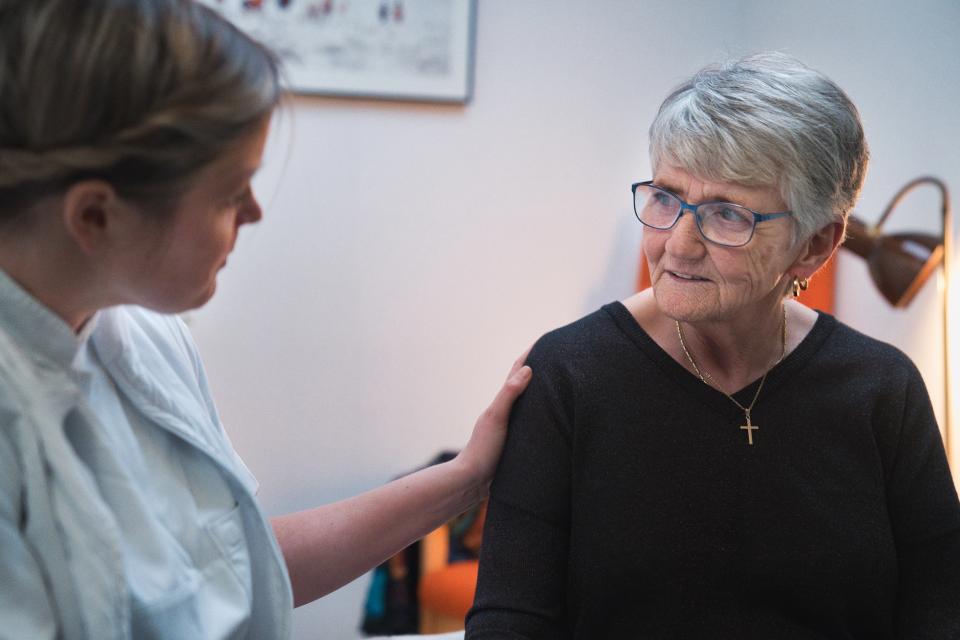 Plejepersonale holder ældre borger på skulderen